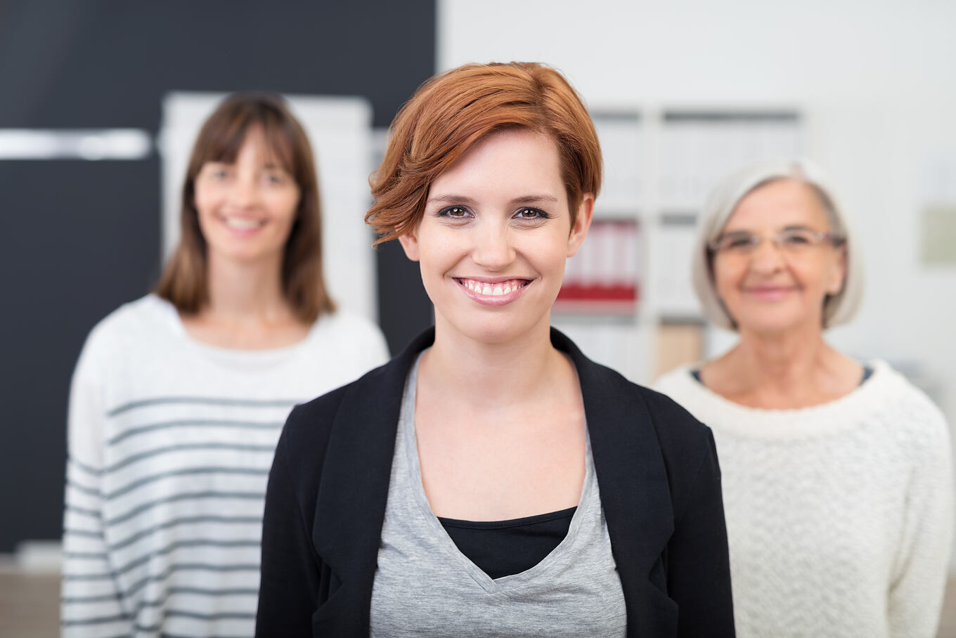 Pretty,Young,Office,Woman,Smiling,At,The,Camera,Against,Her