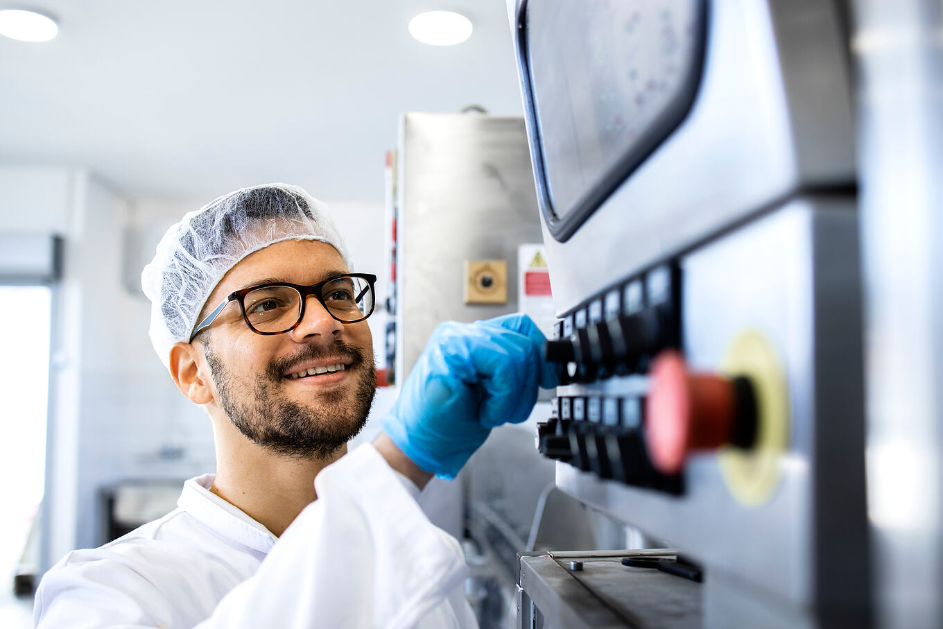 Food,Factory,Worker,In,Sterile,Uniform,And,Hairnet,Operating,Industrial